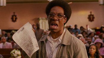 Movie still from “Norbit” (2007), directed by Brian Robbins – A man holding a piece of paper in front of a group of people; Close Up shot, Low angle