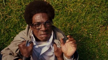 Movie still from “Norbit” (2007), directed by Brian Robbins – A man in a jacket is laying in the grass; Close Up shot, Overhead angle