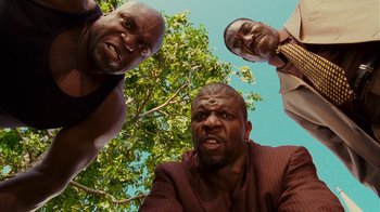 Movie still from “Norbit” (2007), directed by Brian Robbins – A group of men standing next to each other under a tree; Medium shot, Low angle