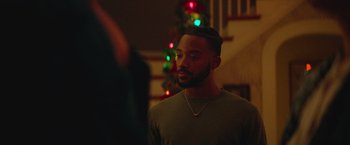 Movie still from “Mother/Android” (2021), directed by Mattson Tomlin – A man with a beard standing in front of a christmas tree; Close Up shot, Over the shoulder angle