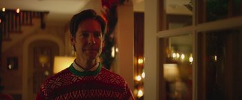 Movie still from “Mother/Android” (2021), directed by Mattson Tomlin – A man wearing a red and green sweater; Close Up shot, Over the shoulder angle