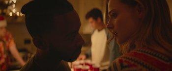 Movie still from “Mother/Android” (2021), directed by Mattson Tomlin – A man and a woman face to face in front of a group of people; Close Up shot, Over the shoulder angle