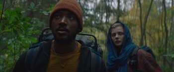 Movie still from “Mother/Android” (2021), directed by Mattson Tomlin – A man and a woman are walking through the woods; Close Up shot, Low angle