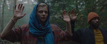 Movie still from “Mother/Android” (2021), directed by Mattson Tomlin – A woman with a blue head scarf is holding her hands up in the air; Close Up shot, Low angle