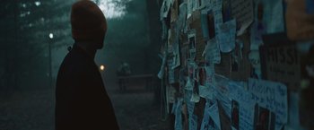 Movie still from “Mother/Android” (2021), directed by Mattson Tomlin – A person standing in front of a wall covered in papers; Extreme Close Up shot, Over the shoulder angle