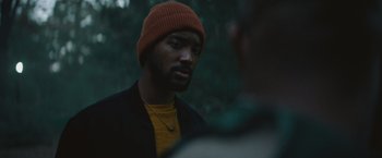 Movie still from “Mother/Android” (2021), directed by Mattson Tomlin – A person wearing a hat; Close Up shot, Over the shoulder angle