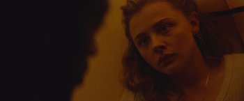 Movie still from “Mother/Android” (2021), directed by Mattson Tomlin – A woman looking at the camera in front of a mirror; Close Up shot, Over the shoulder angle