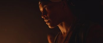 Movie still from “Mother/Android” (2021), directed by Mattson Tomlin – A person wearing a hat and a necklace; Close Up shot, Low angle