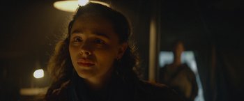 Movie still from “Mother/Android” (2021), directed by Mattson Tomlin – A woman is looking at the camera with a light shining on her face; Close Up shot, Over the shoulder angle