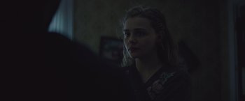 Movie still from “Mother/Android” (2021), directed by Mattson Tomlin – A woman is looking at the camera in the dark; Close Up shot, Over the shoulder angle