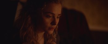 Movie still from “Mother/Android” (2021), directed by Mattson Tomlin – A young woman is looking down at her face; Close Up shot, Over the shoulder angle