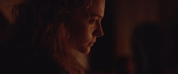 Movie still from “Mother/Android” (2021), directed by Mattson Tomlin – A person's face in the dark; Close Up shot, Low angle