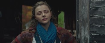 Movie still from “Mother/Android” (2021), directed by Mattson Tomlin – A woman with her eyes closed with her eyes closed; Close Up shot, Over the shoulder angle