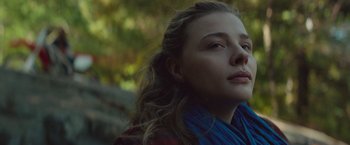 Movie still from “Mother/Android” (2021), directed by Mattson Tomlin – A young woman with long brown hair wearing a red and blue scarf; Close Up shot, Low angle