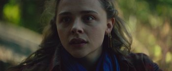 Movie still from “Mother/Android” (2021), directed by Mattson Tomlin – A person wearing a scarf and earrings; Close Up shot, Low angle