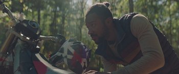 Movie still from “Mother/Android” (2021), directed by Mattson Tomlin – A man with a beard is leaning on a wall; Close Up shot, Over the shoulder angle