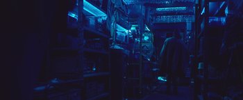 Movie still from “Mother/Android” (2021), directed by Mattson Tomlin – A man standing inside of a room in a store; Wide shot, Low angle