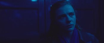 Movie still from “Mother/Android” (2021), directed by Mattson Tomlin – A woman in a blue room looking at the camera; Close Up shot, Low angle