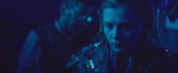 Movie still from “Mother/Android” (2021), directed by Mattson Tomlin – A young woman in a blue room looking sad; Close Up shot, Over the shoulder angle