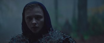 Movie still from “Mother/Android” (2021), directed by Mattson Tomlin – A woman wearing a blue hood and a bunch of pins; Close Up shot, Low angle