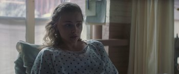 Movie still from “Mother/Android” (2021), directed by Mattson Tomlin – A young woman sitting in a hospital bed; Close Up shot, Over the shoulder angle