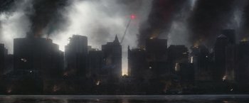 Movie still from “Mother/Android” (2021), directed by Mattson Tomlin – A red light is seen in the background of a large city fire; Extreme Wide shot, High angle