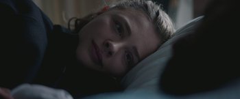 Movie still from “Mother/Android” (2021), directed by Mattson Tomlin – A woman laying in a bed looking at the camera; Close Up shot, Over the shoulder angle