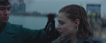 Movie still from “Mother/Android” (2021), directed by Mattson Tomlin – A person taking a picture of a woman's face with a cell phone; Close Up shot, Over the shoulder angle