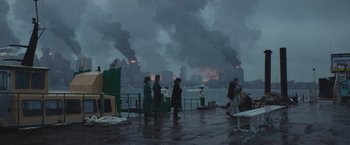 Movie still from “Mother/Android” (2021), directed by Mattson Tomlin – A group of people standing next to a body of water; Extreme Wide shot, High angle