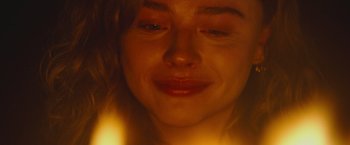 Movie still from “Mother/Android” (2021), directed by Mattson Tomlin – A woman's face in front of a lit candle; Extreme Close Up shot, Overhead angle