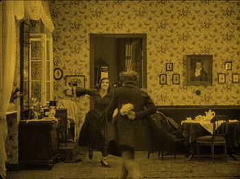 Movie still from “Nosferatu” (1922), directed by F.W. Murnau – An old photo of two people dancing in a living room; Wide shot, High angle