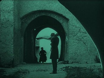 Movie still from “Nosferatu” (1922), directed by F.W. Murnau – A man standing in front of an archway; Wide shot, Low angle