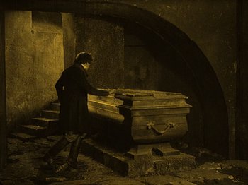 Movie still from “Nosferatu” (1922), directed by F.W. Murnau – A man standing in front of an empty casket; Wide shot, High angle