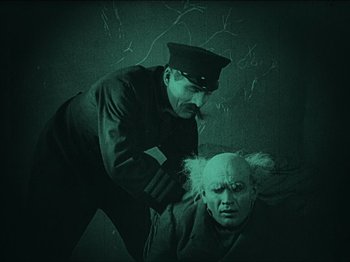 Movie still from “Nosferatu” (1922), directed by F.W. Murnau – A man in a uniform and a man with a white wig; Medium shot, High angle