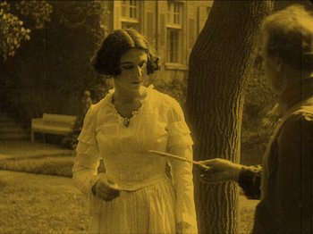Movie still from “Nosferatu” (1922), directed by F.W. Murnau – An old photo of a woman holding a knife in her hand; Medium shot, High angle