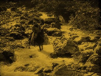 Movie still from “Nosferatu” (1922), directed by F.W. Murnau – A man riding a horse through a stream of water; Extreme Wide shot, High angle
