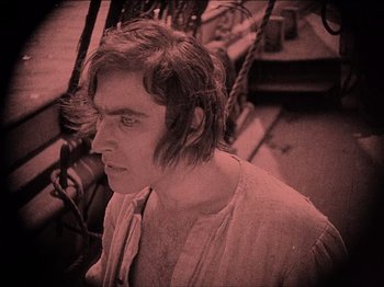 Movie still from “Nosferatu” (1922), directed by F.W. Murnau – A man with long brown hair is looking at the camera; Medium shot, High angle