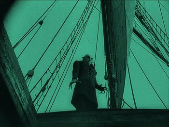 Movie still from “Nosferatu” (1922), directed by F.W. Murnau – A person standing on top of a boat in the water; Wide shot, Low angle