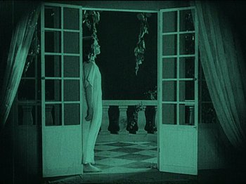 Movie still from “Nosferatu” (1922), directed by F.W. Murnau – A man standing in front of a door at night; Wide shot, High angle