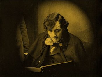 Movie still from “Nosferatu” (1922), directed by F.W. Murnau – A man reading a book while sitting in a chair; Close Up shot, High angle