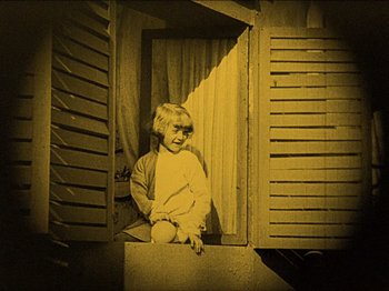Movie still from “Nosferatu” (1922), directed by F.W. Murnau – A young child sitting in a window sill; Medium shot, High angle