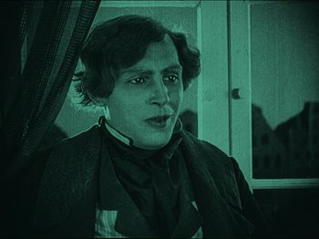 Movie still from “Nosferatu” (1922), directed by F.W. Murnau – A man in a suit is looking at the camera; Medium shot, High angle