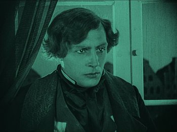 Movie still from “Nosferatu” (1922), directed by F.W. Murnau – A man in a suit is looking at the camera; Medium shot, High angle