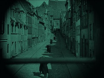 Movie still from “Nosferatu” (1922), directed by F.W. Murnau – An image of a person walking down the street; Extreme Wide shot, High angle
