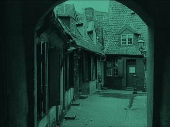 Movie still from “Nosferatu” (1922), directed by F.W. Murnau – An image of an alley way in the middle of the night; Extreme Wide shot, High angle