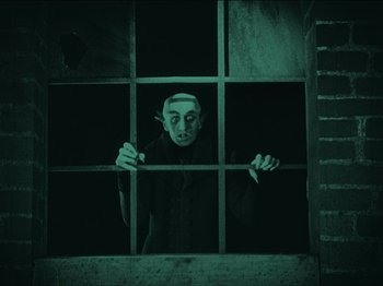 Movie still from “Nosferatu” (1922), directed by F.W. Murnau – A man in a black shirt is behind bars; Medium shot, Low angle
