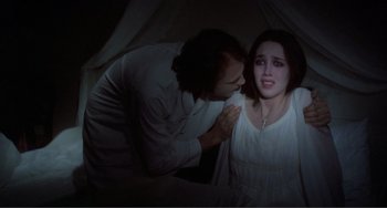 Movie still from “Nosferatu the Vampyre” (1979), directed by Werner Herzog – A man and a woman in a dark room; Medium shot, High angle