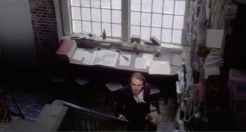 Movie still from “Nosferatu the Vampyre” (1979), directed by Werner Herzog – A man standing in front of a desk in a room; Wide shot, High angle