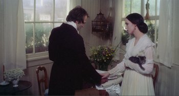 Movie still from “Nosferatu the Vampyre” (1979), directed by Werner Herzog – A man and a woman holding hands in front of a window; Medium shot, Over the shoulder angle