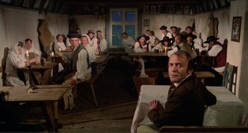 Movie still from “Nosferatu the Vampyre” (1979), directed by Werner Herzog – A group of people sitting around a table; Wide shot, High angle